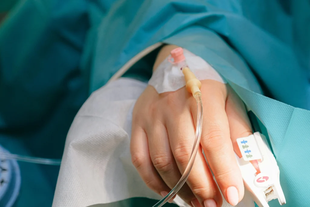 a person's hand is featured with an IV in it
